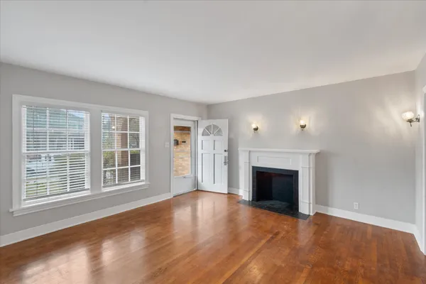 wooden floor fireplace and windows in an empty room