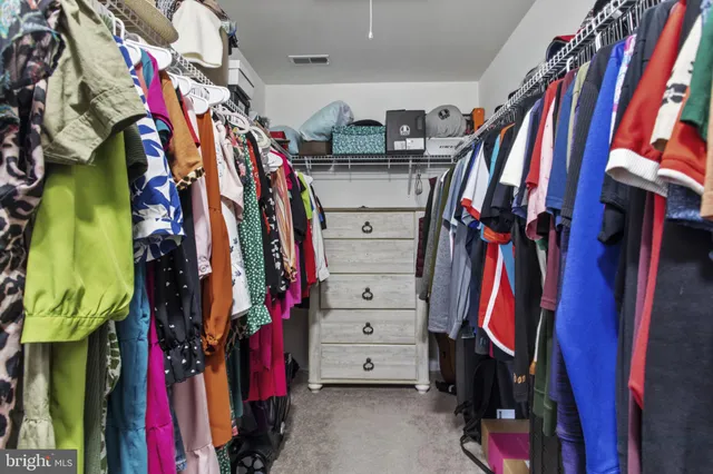 a view of walk in closet with clothes
