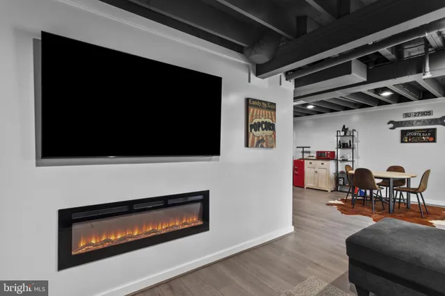 a living room with furniture a flat screen tv and a fireplace