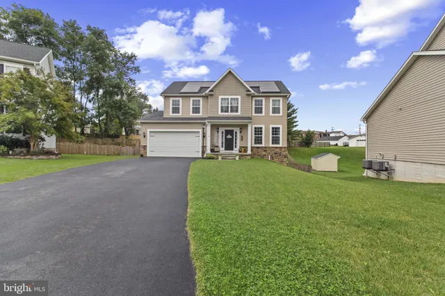a view of a house with a big yard and large trees