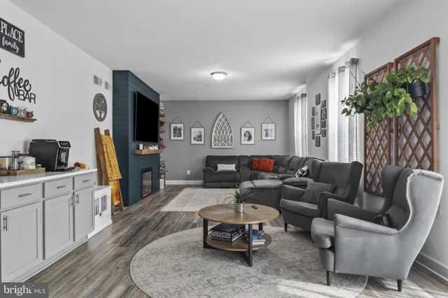 a living room with furniture a flat screen tv and a large window