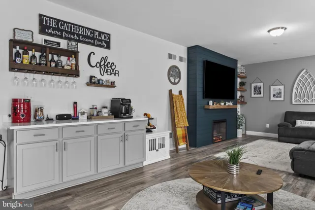 a living room with furniture a flat screen tv and kitchen view