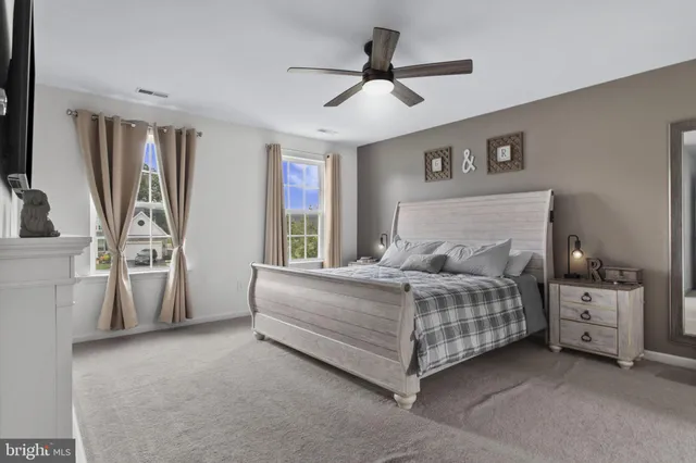 a spacious bedroom with a bed and a ceiling fan