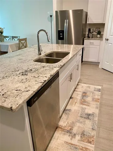 a kitchen with sink and refrigerator