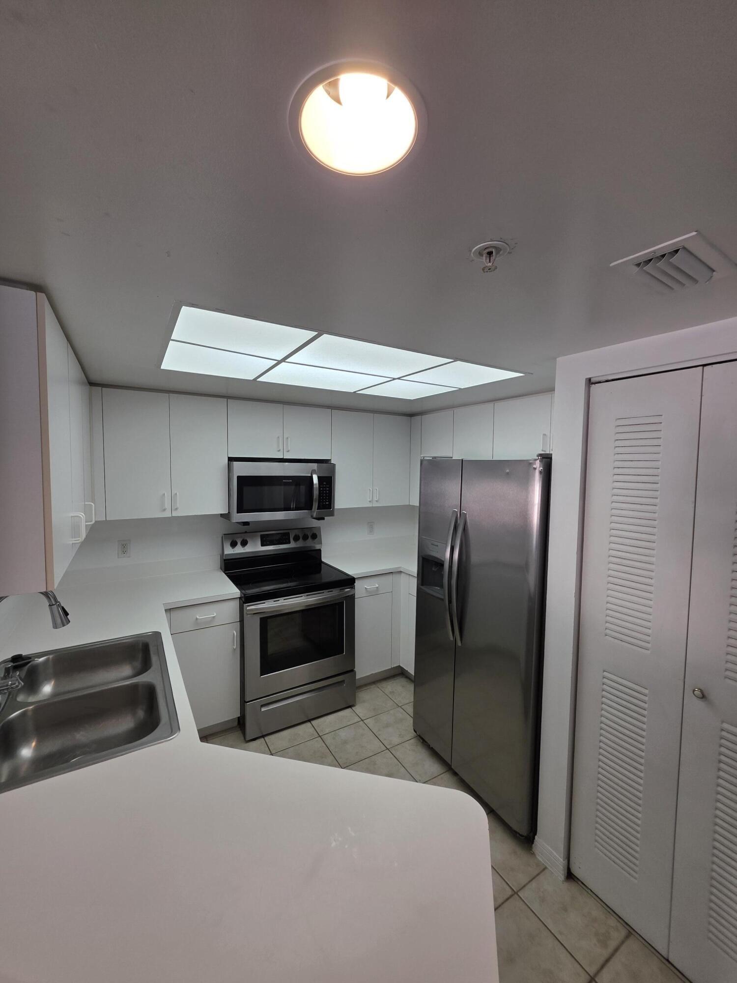 4175 Haverhill Road, Unit 907 West Palm Beach, FL 33417 - Photo 15 of 38 a kitchen with stainless steel appliances granite countertop a refrigerator and a sink
