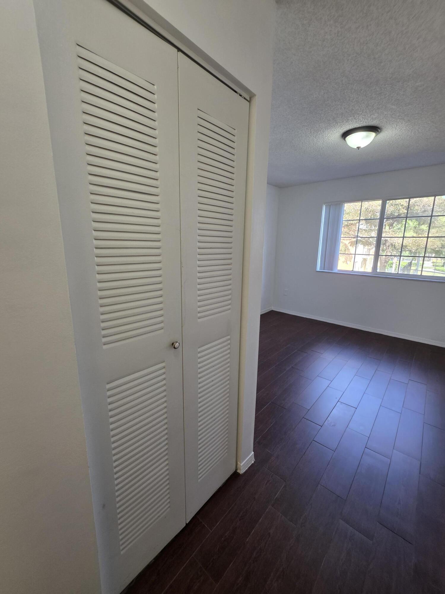 4175 Haverhill Road, Unit 907 West Palm Beach, FL 33417 - Photo 28 of 38 an empty room with wooden floor and windows