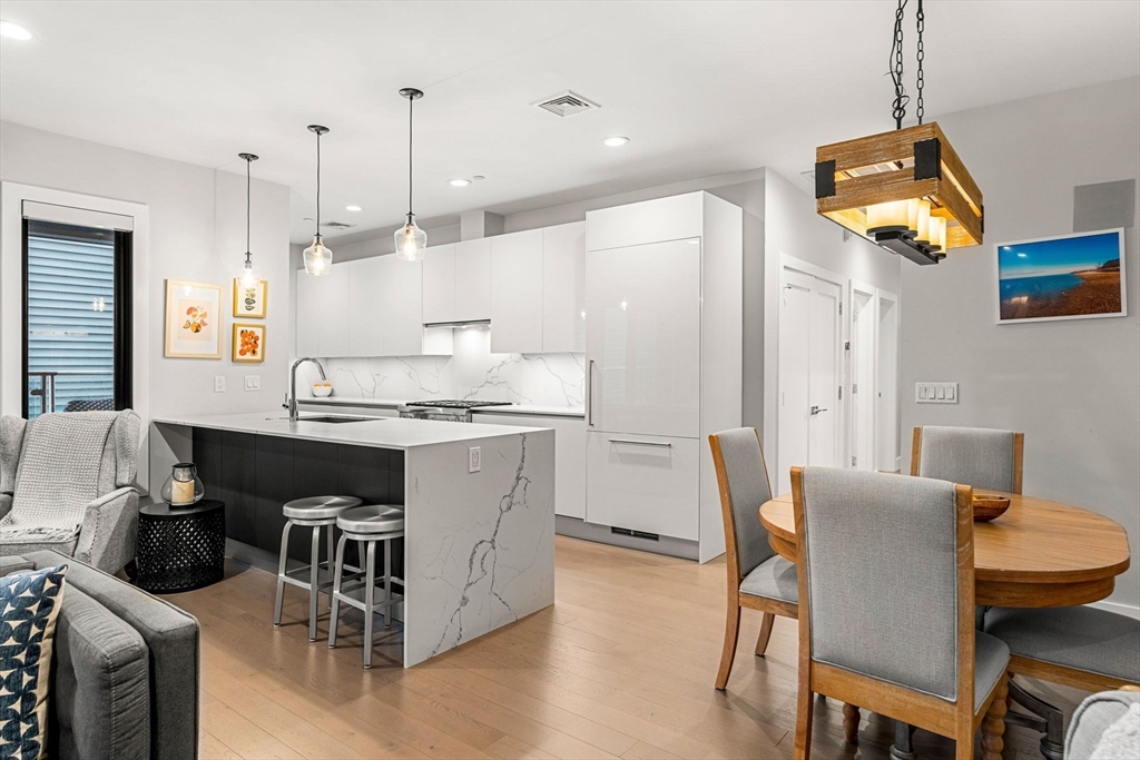 39 A Street, Unit 4 Boston, MA 02127 - Photo 1 of 28 a kitchen with stainless steel appliances granite countertop a table chairs and a wooden floor