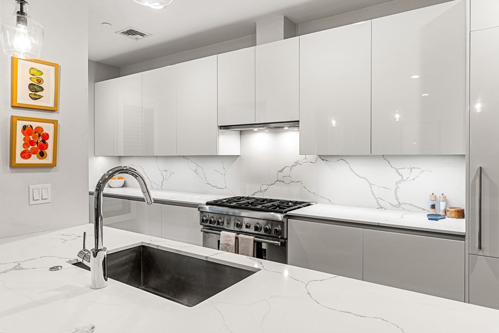 39 A Street, Unit 4 Boston, MA 02127 - Photo 11 of 28 a kitchen with granite countertop a sink a stove and cabinets