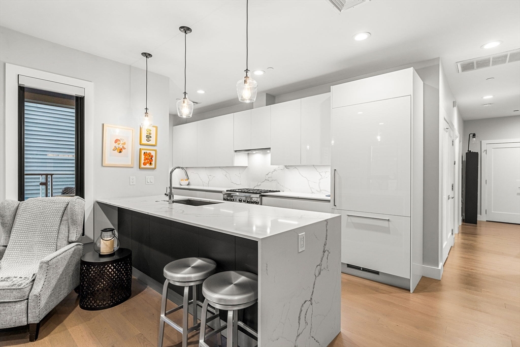 39 A Street, Unit 4 Boston, MA 02127 - Photo 6 of 28 a kitchen with stainless steel appliances a sink a stove a refrigerator and island with wooden floor