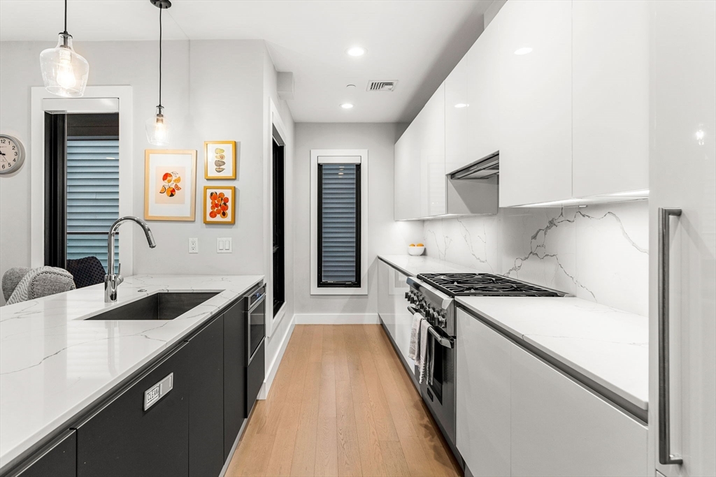 39 A Street, Unit 4 Boston, MA 02127 - Photo 8 of 28 a kitchen with granite countertop a sink stove and cabinets