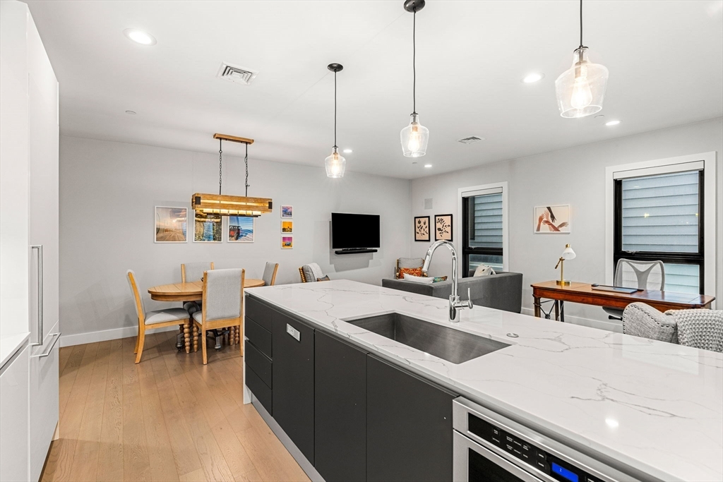 39 A Street, Unit 4 Boston, MA 02127 - Photo 9 of 28 a view of a kitchen with kitchen island a sink a counter and chairs