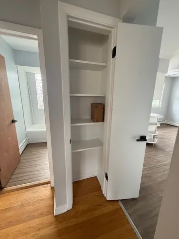 a view of a room with wooden floor and white walls
