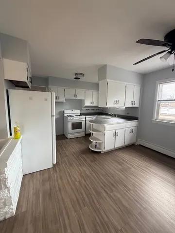 a kitchen with stainless steel appliances a white cabinets and wooden floors
