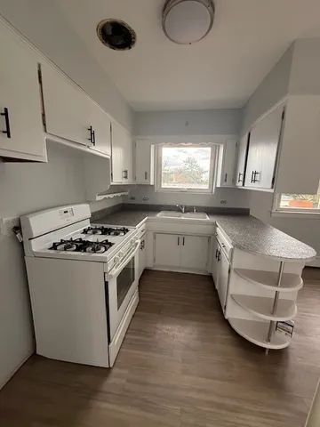 a kitchen with a stove sink and cabinets