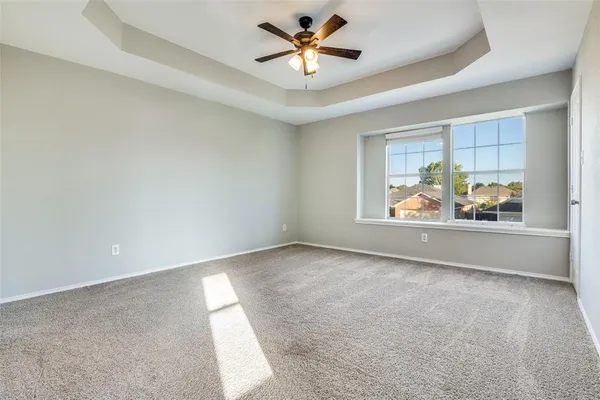 an empty room with windows and ceiling fan view