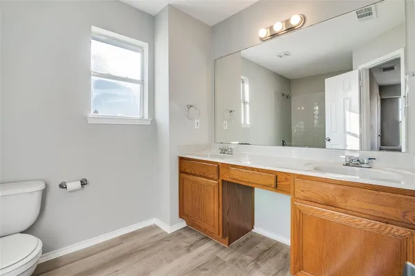 a spacious bathroom with a granite countertop sink toilet and a mirror