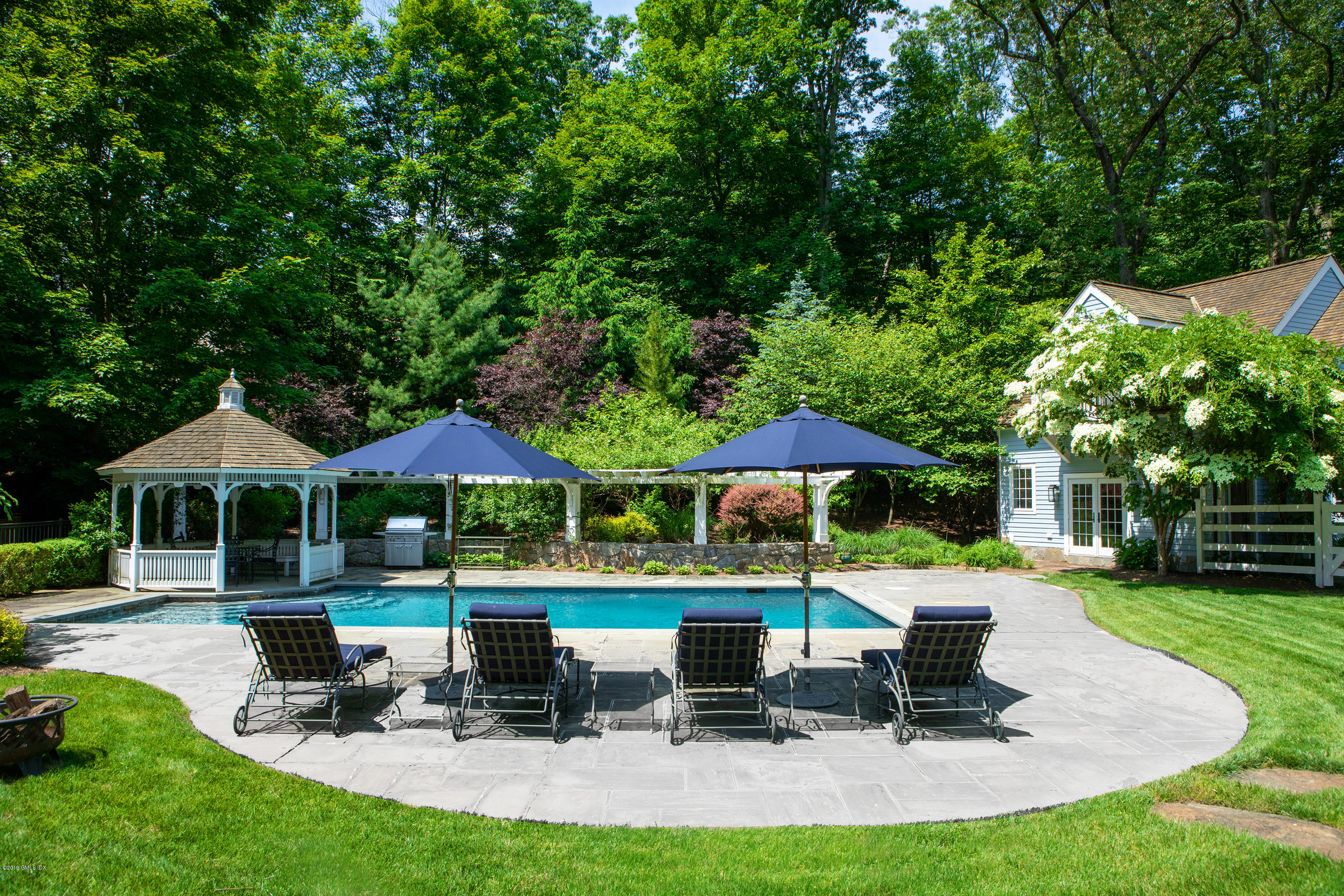 178 Cat Rock Road Cos Cob, CT 06807 - Photo 18 of 26 a patio with a table and chairs under an umbrella