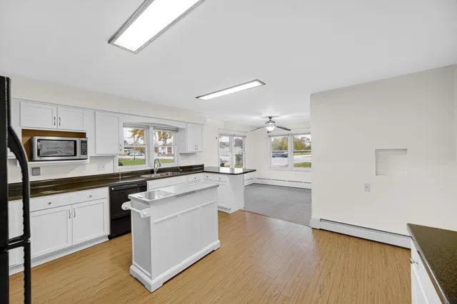 a large kitchen with cabinets wooden floor and stainless steel appliances