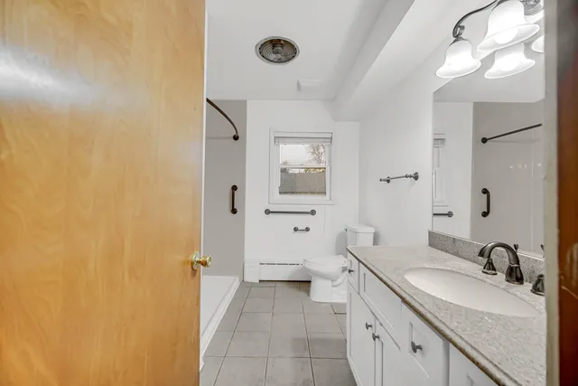 a spacious bathroom with a granite countertop sink and a mirror