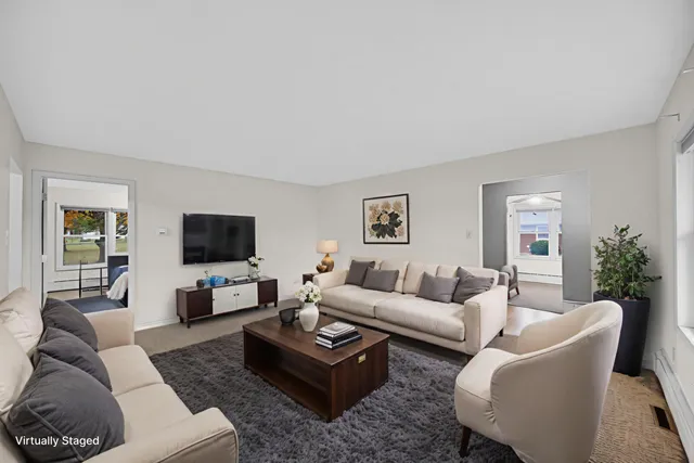 a living room with furniture a rug a window and a flat screen tv