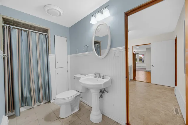 a bathroom with a sink toilet and a mirror