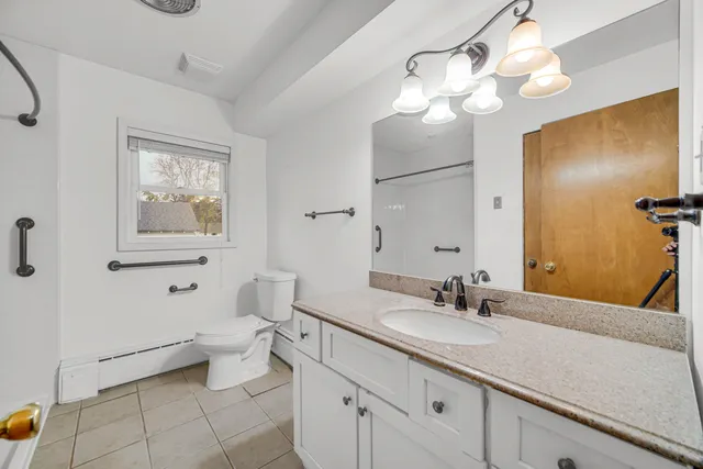 a bathroom with a toilet a sink and mirror