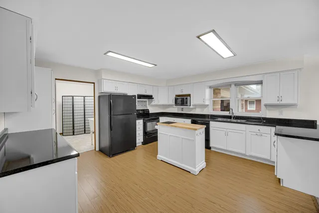 a kitchen with stainless steel appliances granite countertop a refrigerator sink and cabinets