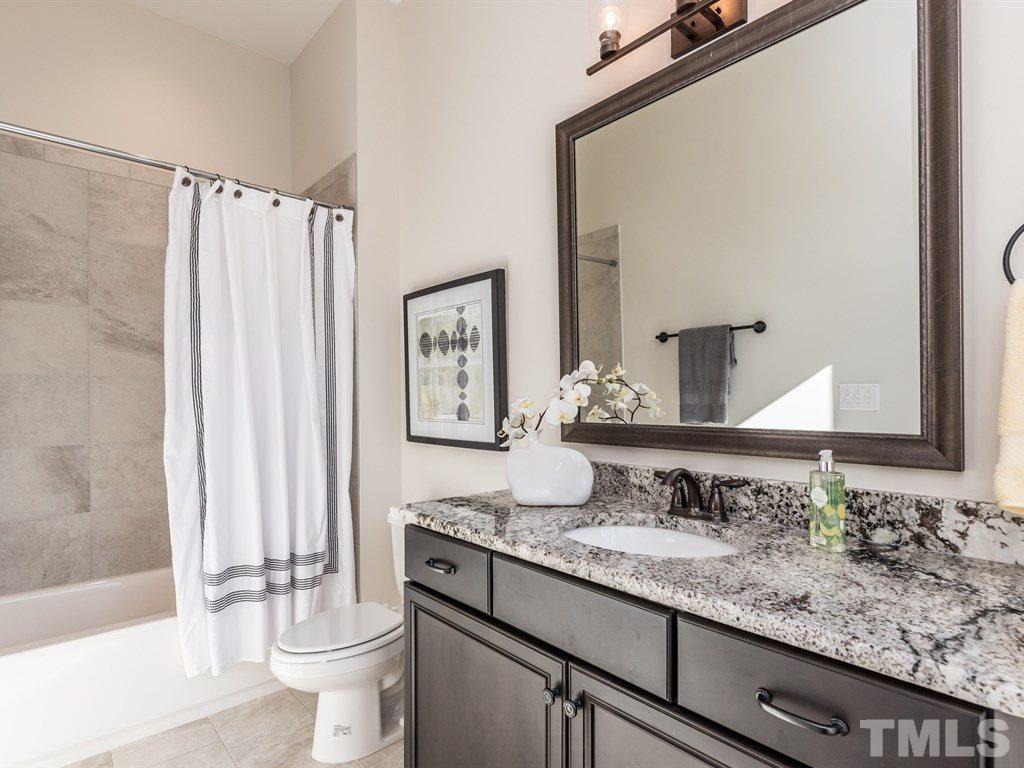 5216 Woodall Way, Unit 13 Raleigh, NC 27613 - Photo 15 of 25 a bathroom with a granite countertop sink and a mirror