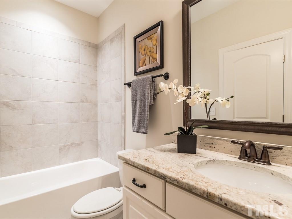 5216 Woodall Way, Unit 13 Raleigh, NC 27613 - Photo 17 of 25 a bathroom with a granite countertop sink toilet and shower