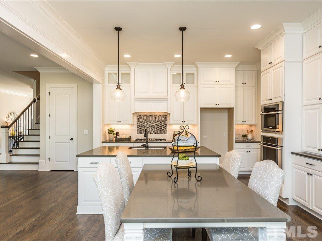 5216 Woodall Way, Unit 13 Raleigh, NC 27613 - Photo 7 of 25 a dining table chairs and kitchen view with wooden floor