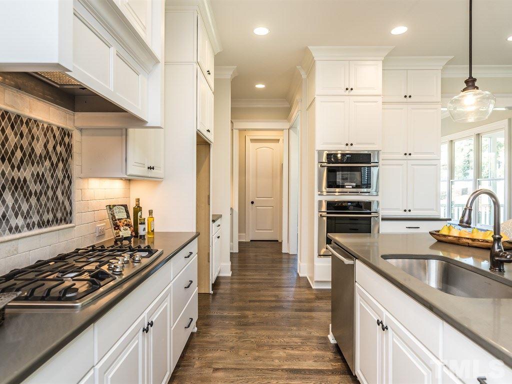 5216 Woodall Way, Unit 13 Raleigh, NC 27613 - Photo 8 of 25 a kitchen with stainless steel appliances a stove a sink and a refrigerator