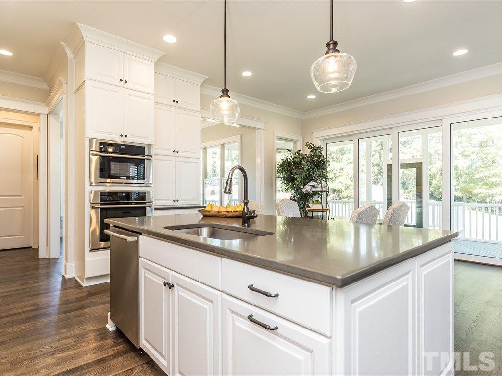 5216 Woodall Way, Unit 13 Raleigh, NC 27613 - Photo 9 of 25 a kitchen with stainless steel appliances granite countertop a sink a stove and a refrigerator