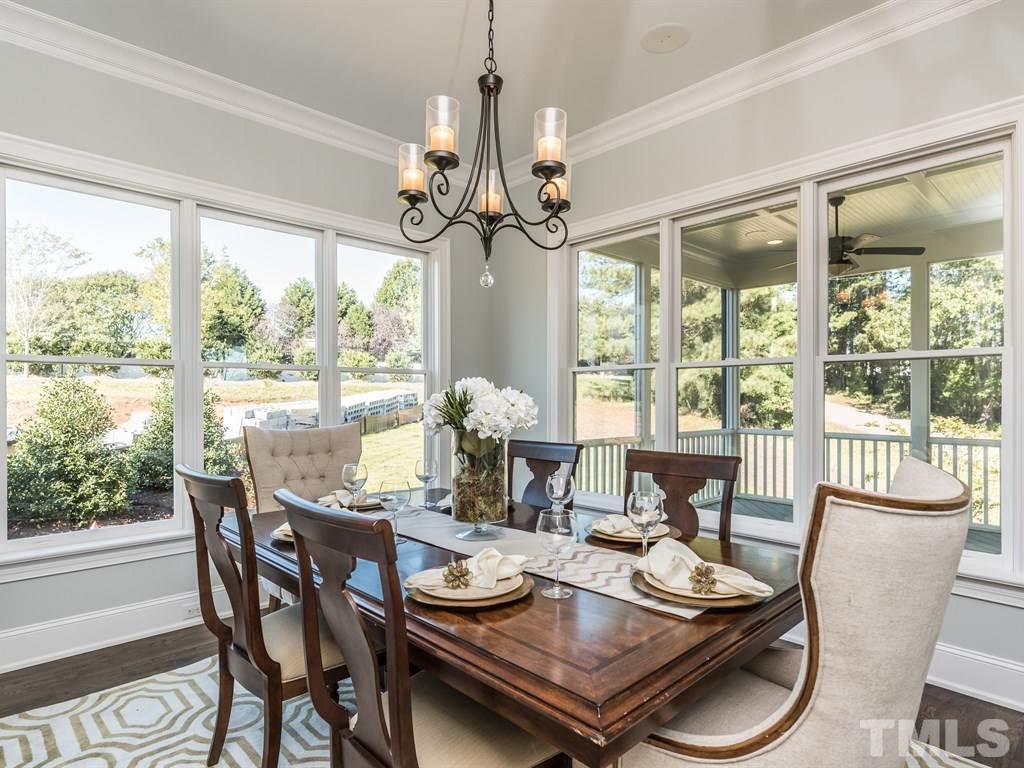 5216 Woodall Way, Unit 13 Raleigh, NC 27613 - Photo 10 of 25 a view of a dining room with furniture a chandelier and large windows
