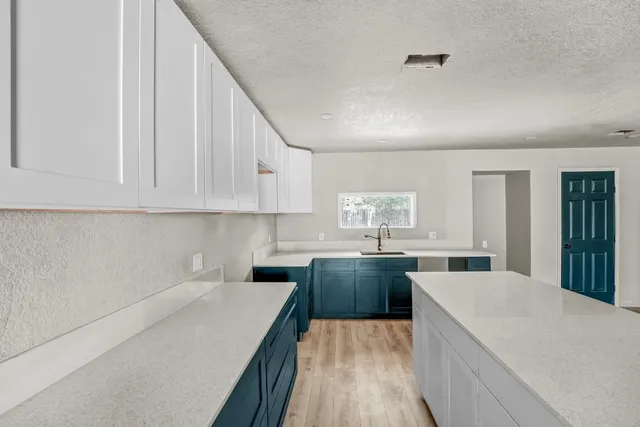 a kitchen with stainless steel appliances a sink a stove top oven a counter space and cabinets