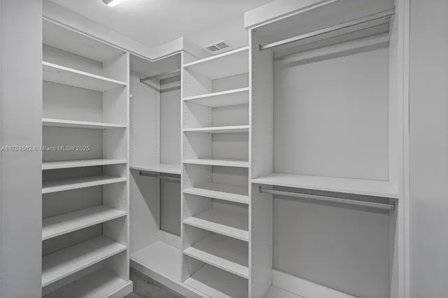 a view of walk in closet with empty racks