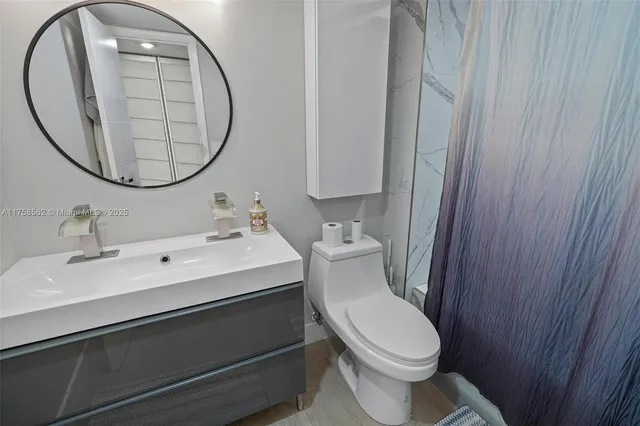 a white toilet sitting next to a bathroom sink