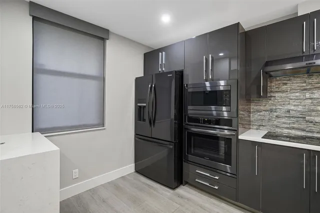 a metallic refrigerator freezer sitting in a kitchen