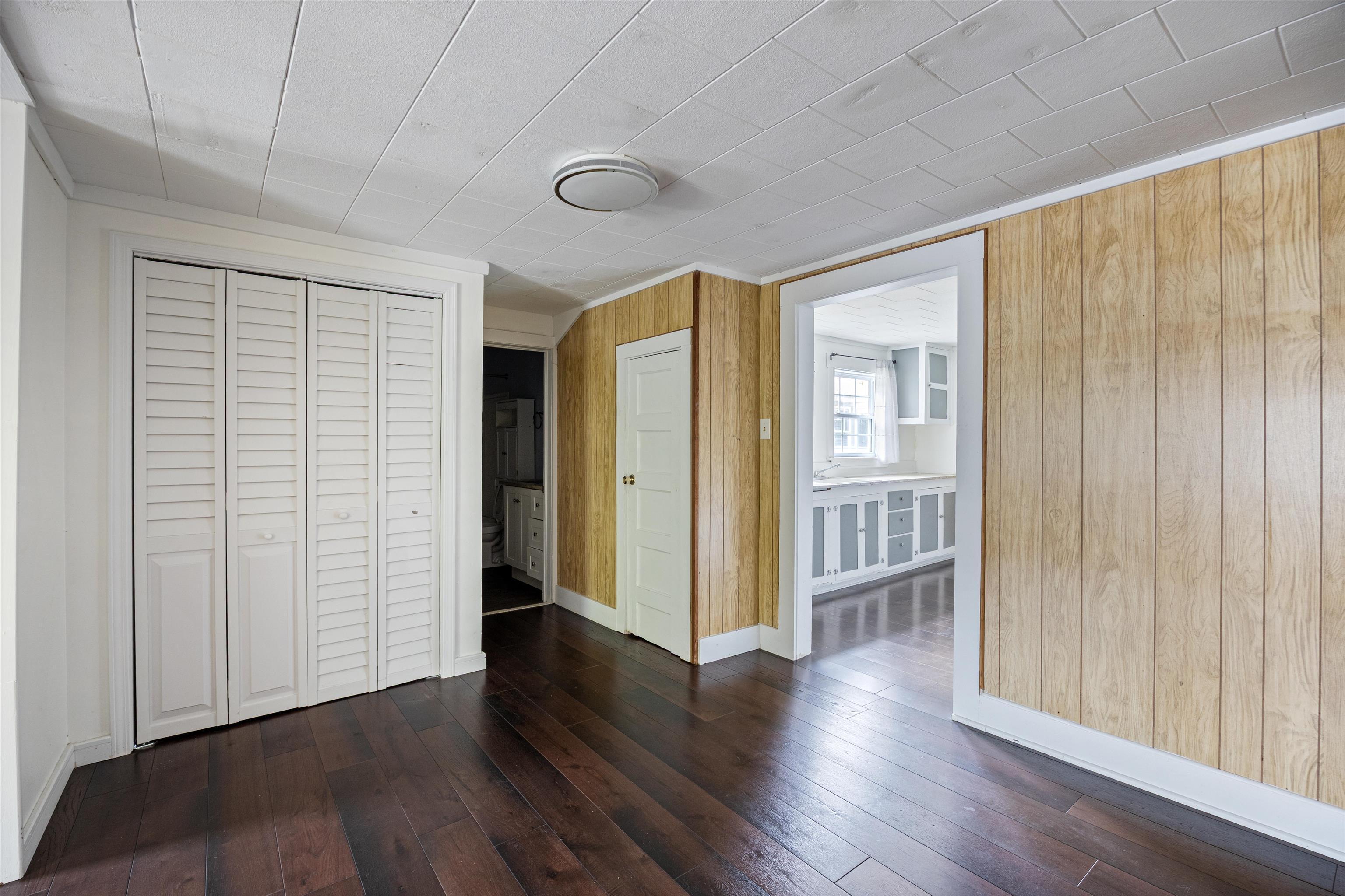 112 South Juniper Street Foley, AL 36535 - Photo 16 of 64 Unfurnished bedroom with a closet, dark wood finished floors, and wood walls