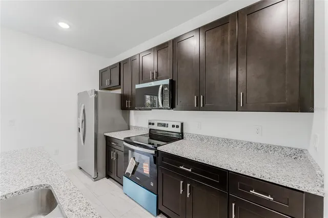 a kitchen with stainless steel appliances granite countertop a sink stove and refrigerator