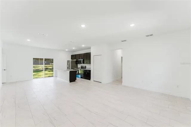 an empty room with furniture and a large window