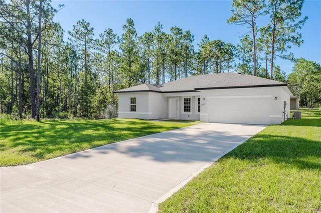 a white house with a small yard and wooden fence