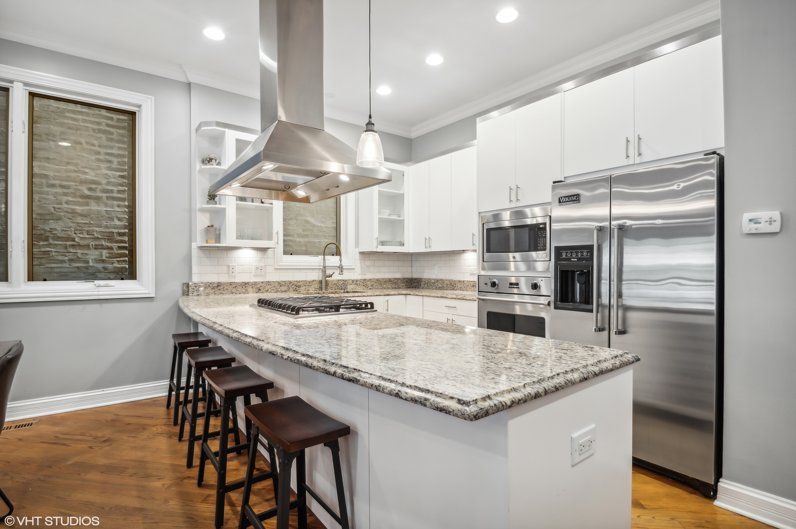 1131 West Addison Street, Unit 1 Chicago, IL 60613 - Photo 7 of 27 a kitchen with stainless steel appliances granite countertop a sink a stove and a refrigerator