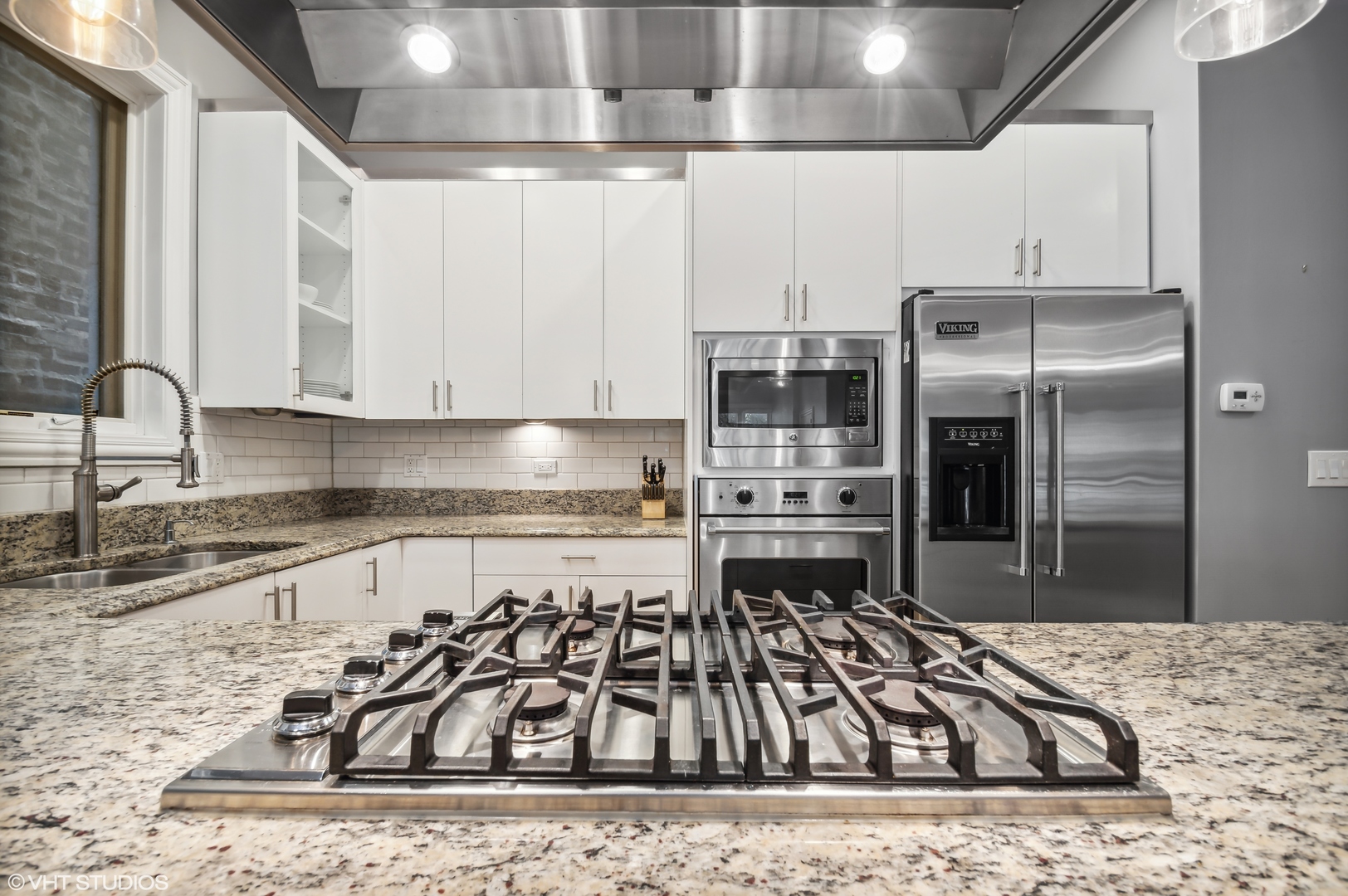 1131 West Addison Street, Unit 1 Chicago, IL 60613 - Photo 8 of 27 a kitchen with kitchen island a counter top space a sink stainless steel appliances and cabinets