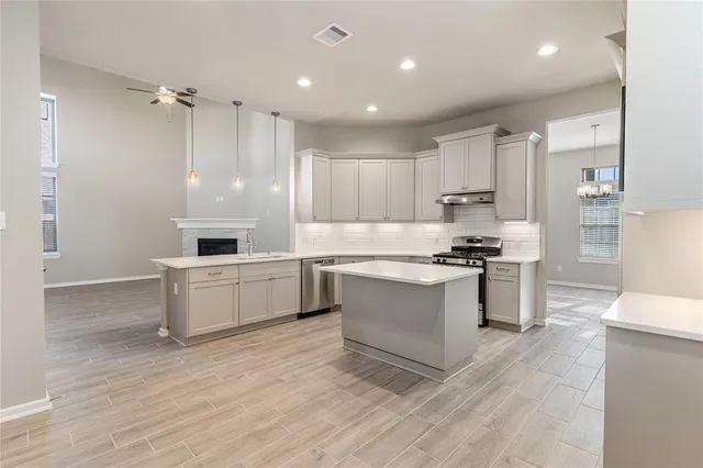 a kitchen with a refrigerator and white cabinets