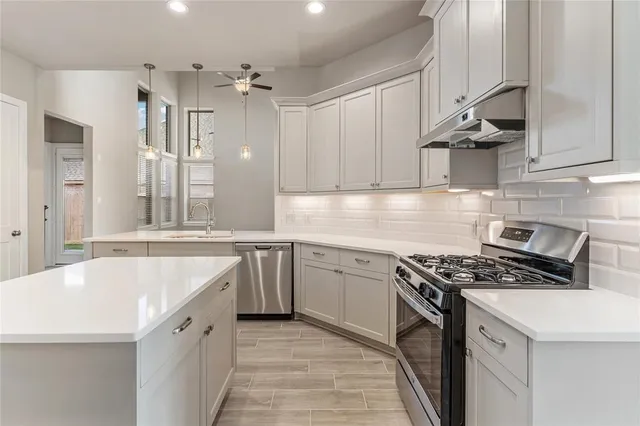 a kitchen with granite countertop a sink stove and cabinets