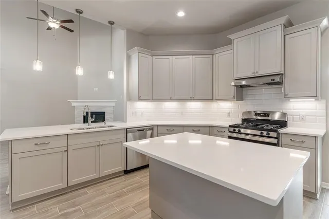 a kitchen with a sink a stove and cabinets
