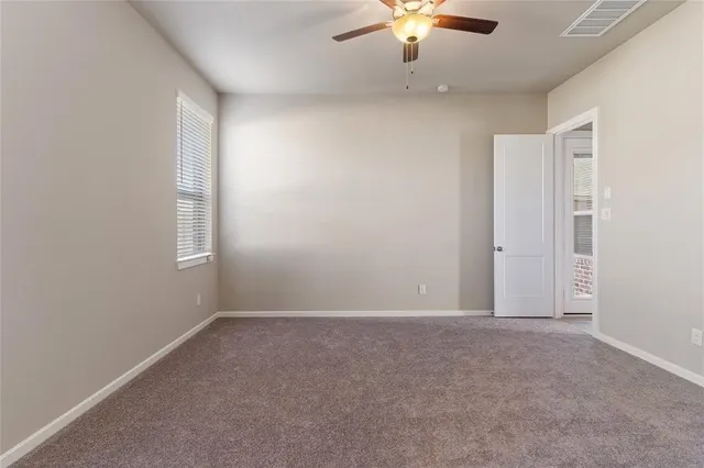 an empty room with a chandelier fan