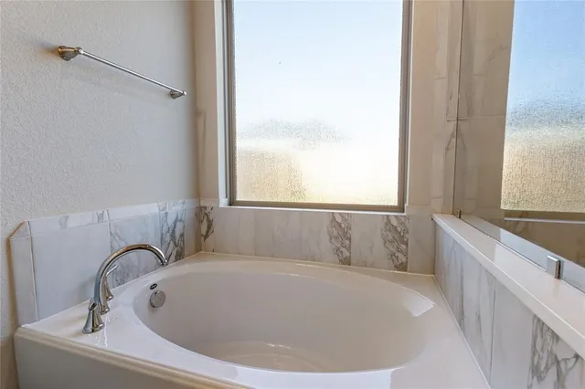 a bathroom with a bathtub and a window