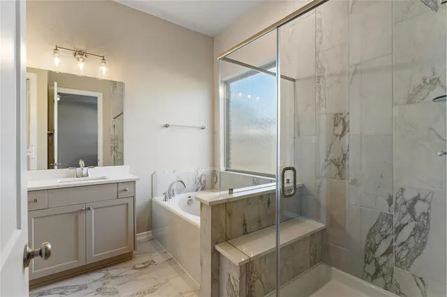 a bathroom with a tub sink and mirror