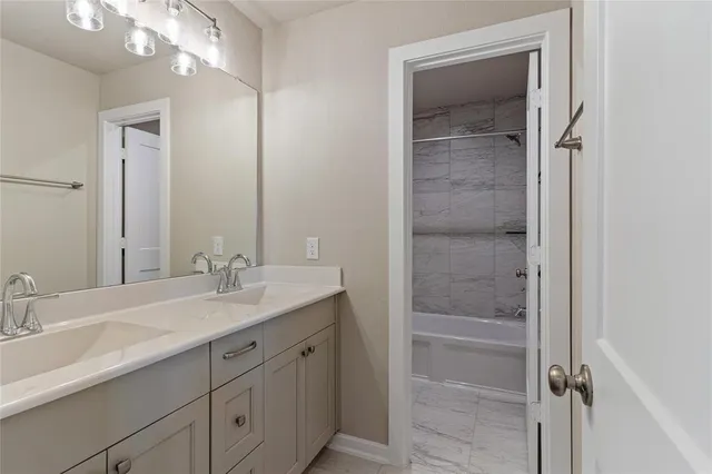 a bathroom with a shower sink vanity and mirror